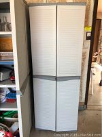 Frontal view of the closed tall plastic storage cabinet with four doors, showing the slatted door design and gray handles.