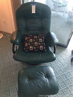 Front view of dark green leather recliner chair and matching ottoman, showing overall condition and styling.