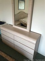 Wide view of the light wood dresser positioned under the mirror, showing front drawer detail and finish.