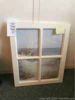 Full view of the white wooden picture frame with beach landscape divided into four sections.