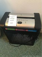 Front and top view of Embassy TQ80mc paper shredder showing control panel, brand name and shredded paper bin.