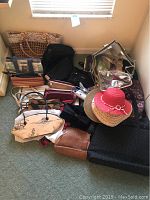 Overall assortment showing many handbags and purses in various designs and colors, with three women's hats on top.