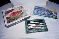 Boxed Dolomite Christmas serving platter, oval frosted crystal platter box, and boxed three-piece silverplated grape design serving set