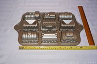 Top view of the Nordic Ware Train Cake Pan with visible detailed compartments for the train engine and cars. Includes measuring tape and ruler for scale.