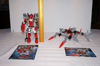 Photo showing both Furno and Jaw Blade figures standing on a white surface with a ruler for scale and original instruction booklets in front
