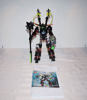 Assembled Lego Hero Factory Black Phantom figure standing with original instruction manual displayed in front.