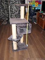 Full view of the grey cat tower showing three levels, two sisal-wrapped posts and a cubed hideout on the middle platform