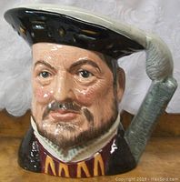 Front view of the Royal Doulton Henry VIII Toby jug highlighting detailed facial features and hat.