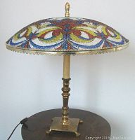 Full view of the Mid-Century Modern table lamp showing brass base, stem, and the colorful mosaic glass shade with floral and geometric designs.