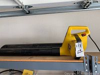 Side view of yellow Paramount leaf blower showing its elongated black nozzle and yellow handle.
