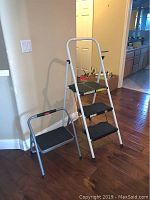 Full view showing both step stools: a taller Rubbermaid three-step stool and a smaller one-step Stapleton stool