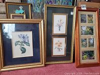 Overview of three framed floral art pieces: blue flower print, double yellow floral print, and carved wood framed nature photo collage