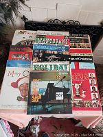 Top view of multiple vintage holiday music vinyl albums laid out, showing colorful and festive covers with Christmas themes and various artists.