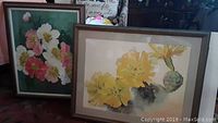 Two framed floral artworks together: one print with pink and white flowers, one original oil painting with yellow cactus flowers
