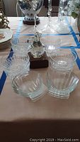 Photo showing eight Arcoroc France crystal bowls arranged around a hand-blown glass Penguin nightlight on a wooden base