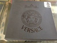 Box with Versace and Rosenthal branding in black with Medusa logo on grey background