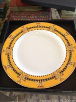 Yellow and black ornate border of one Versace plate inside a black box