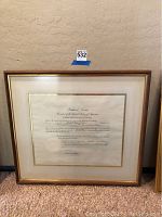 Full view of the framed Richard Nixon patent letter against a wall and carpeted floor.