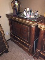 Full view of dresser showing ornate gold detailing and three drawer fronts with handles.