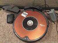 Top view of iRobot Roomba vacuum showing copper-colored top with control panel and CLEAN button.