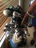 Photo showing the clubs inside the Callaway golf bag including irons, pitching wedge, driver clubs, some with head covers.