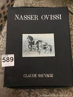Exterior of black portfolio case with “NASSER OVISSI” and “CLAUDE SAUVAGE” text and central horse illustration