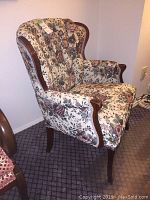 Full side angle of the upholstered mahogany chair showing floral fabric upholstery and wood frame.