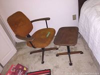 Teak desk chair with orange-brown upholstery and teak side table next to bed, showing overall look and scale
