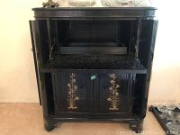 Front view of closed cabinet showing gold bamboo and floral panels