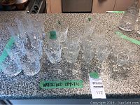 Overview of Waterford crystal glassware set arranged on a countertop, including wine glasses, tumblers, and goblets.