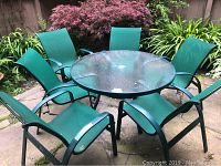 Patio table and six mesh chairs set in garden setting showing table and chairs from above