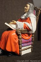 Side view of the Royal Doulton The Judge figurine showing full seated figure in judicial robe and wig, holding open book.