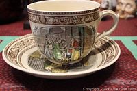 Front view of oversized cup on saucer showing detailed Cries of London scene with figures and decorative border