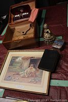 Overview of all items showing wood box, framed print, metal figurine, two books, and small metal box arranged on a table