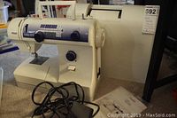Pfaff Hobby 4270 portable sewing machine with power cord, instruction manual, and hard plastic carry case visible in background, displayed on carpeted floor.