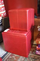 Photo of stacked red leather storage box and ottoman showing size and design