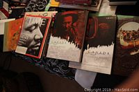 Overview of multiple Canadian history books and a black velvet bowtie, including 'Canada: A People's History' volumes, Time magazine, and other Canadian history literature.