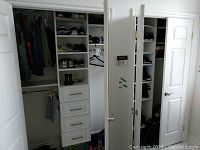 Overall view of white closet organizer with shelves, drawers and rods