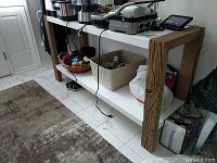 Full view of the wood and Formica table showing rustic wooden legs and white shelf underneath.