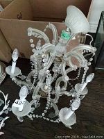 Full view of the chandelier showing six light arms, glass and crystal bead detailing, and overall size.