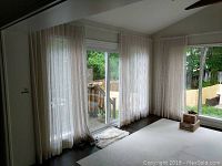 Curtain panels hung in dining room around sliding glass door and adjacent window