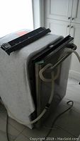 Rear and side view of dishwasher showing insulation wrap, hoses, top rails