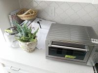 Cuisinart stainless steel toaster oven on counter with measured size label