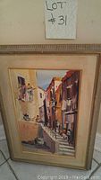 Full view of framed painting showing town alley with people and boats