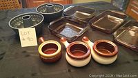 Full set of four Pyrex dishes, six onion soup bowls in two color styles, and two metal bundt cake pans arranged on table.