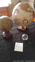 Three globes together on a black cloth, showing size differences and bases