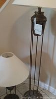 Floor lamp and table lamp next to wall with shades on top