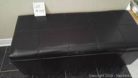 View of entire black vinyl bench showing stitched seat surface.