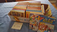 Box filled with approximately 50 comic digest magazines laying flat, showing colorful covers featuring Archie characters.