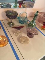 Overview of glass items including carnival glass, Murano ashtray, glass bottle, smaller glass bowls, and glass dog figurines.